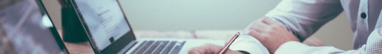 Deux personnes collaborent, une utilise un ordinateur portable, l'autre prend des notes.